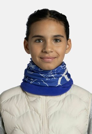 Gaiter de cuello multifuncional azul con patrones florales blancos, hecho de un tejido elástico, llevado con un chaleco acolchado beige.