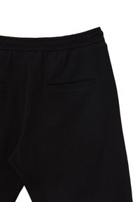 Schwarze Sweatpants mit einem elastischen Bund, ausgestattet mit zwei Gesäßtaschen mit horizontalen Öffnungen und einem weichen, strukturierten Stoff.