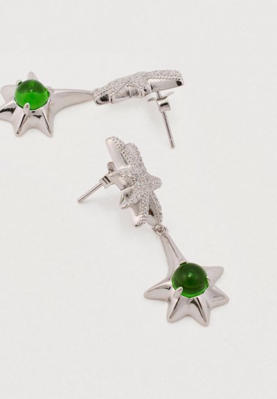 Cercei în formă de stea argintie cu o piatră prețioasă verde netedă în centru. Design texturat de stea de mare pe baza cerceilor.