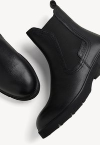 Černé gumové kotníkové boty s texturovaným koženým povrchem, elastickými bočními panely, kulatou špičkou a gumovou podrážkou s profilovaným vzorem.