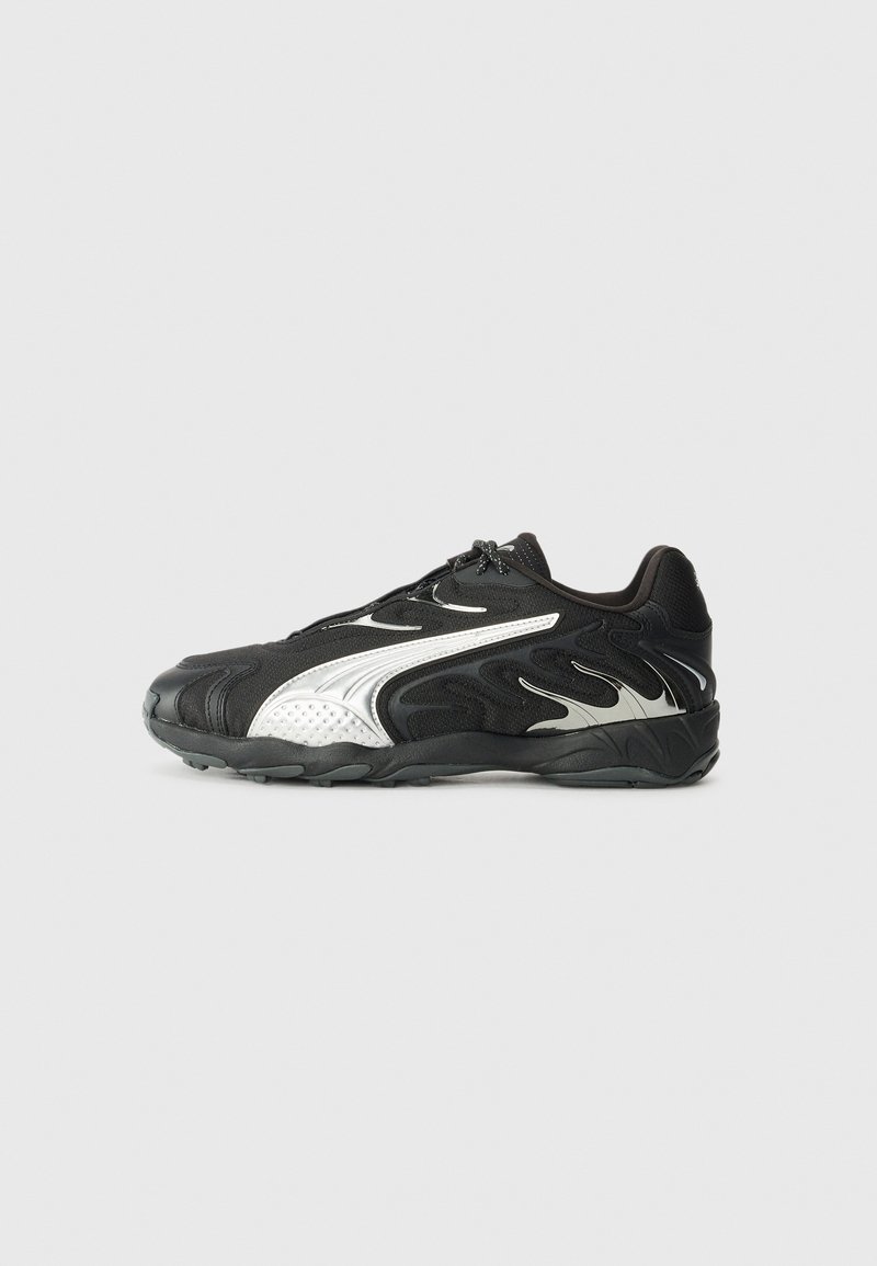 Basket de sport noire avec des motifs blancs en forme de flammes et une semelle épaisse, vue de profil côté gauche sur un fond gris uni.