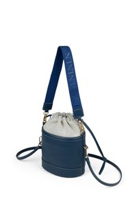 La borsa rotonda presenta una base in pelle blu scuro con una parte superiore in tessuto grigio arricciata, completata da una tracolla blu con logo impresso e accessori dorati.