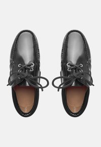 Schwarze Lederschuhe mit glänzender Oberfläche, runder Spitze und traditioneller Schnürung. Verfügt über gestickte Details und ein braunes Innenfutter.