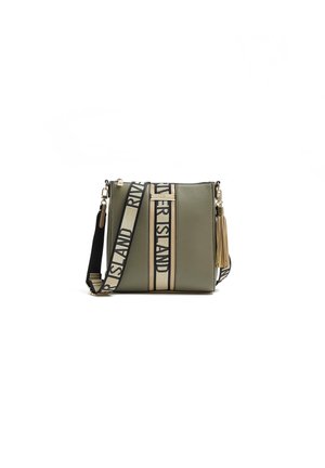 Green crossbody bag with wide beige and black strap labeled "RIVER ISLAND," gold hardware, and beige tassel detail on the side.