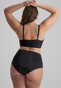 Svart underklädesset med en bralette med justerbara band och högmidjade trosor. Slät textur och sömlös design.