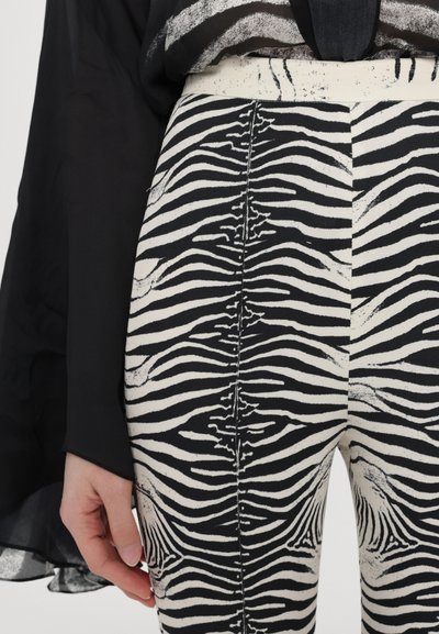 Pantaloni cu imprimeu de zebră alb-negru, din țesătură texturată, având talie înaltă, picioare drepte și o cusătură centrală pe spate.