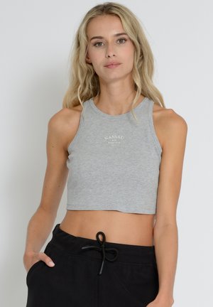 Graues, kurzes Tanktop aus weichem, dehnbarem Material mit rundem Halsausschnitt und bedrucktem "NASSAU"-Logo. Das Model trägt schwarze Jogginghosen mit Kordelzug.