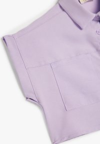 Lavendel kortærmet polo skjorte med krave, der har en brystlomme og glat, tekstureret stof. Renset syninger og moderne design.