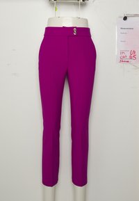 Magenta op maat gemaakte cropped pants met een voornaad, tentoongesteld op een witte mannequin tegen een effen achtergrond met meetnotities in de buurt.