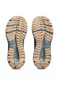 Las suelas de los zapatos presentan una base de goma color beige con ranuras profundas para proporcionar tracción. Los acentos grises a lo largo de los lados realzan el diseño.