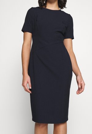 Abito fitted blu navy con maniche corte, scollatura rotonda e dettagli geometrici nelle cuciture. Realizzato in tessuto morbido, silhouette fino al ginocchio.
