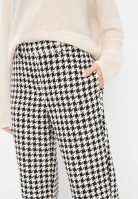Hoge taille, zwart-wit houndstooth-patroon broek met zakken, gemaakt van textuurstof, met een relaxed fit.