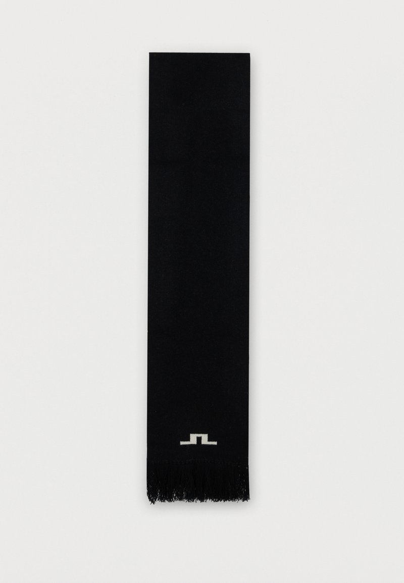 Melnā šalle, kas izgatavota no mīksta auduma, ar elegantu taisnstūra dizainu, ar frizētām malām un nelielu balto logotipu tuvumā apakšai.