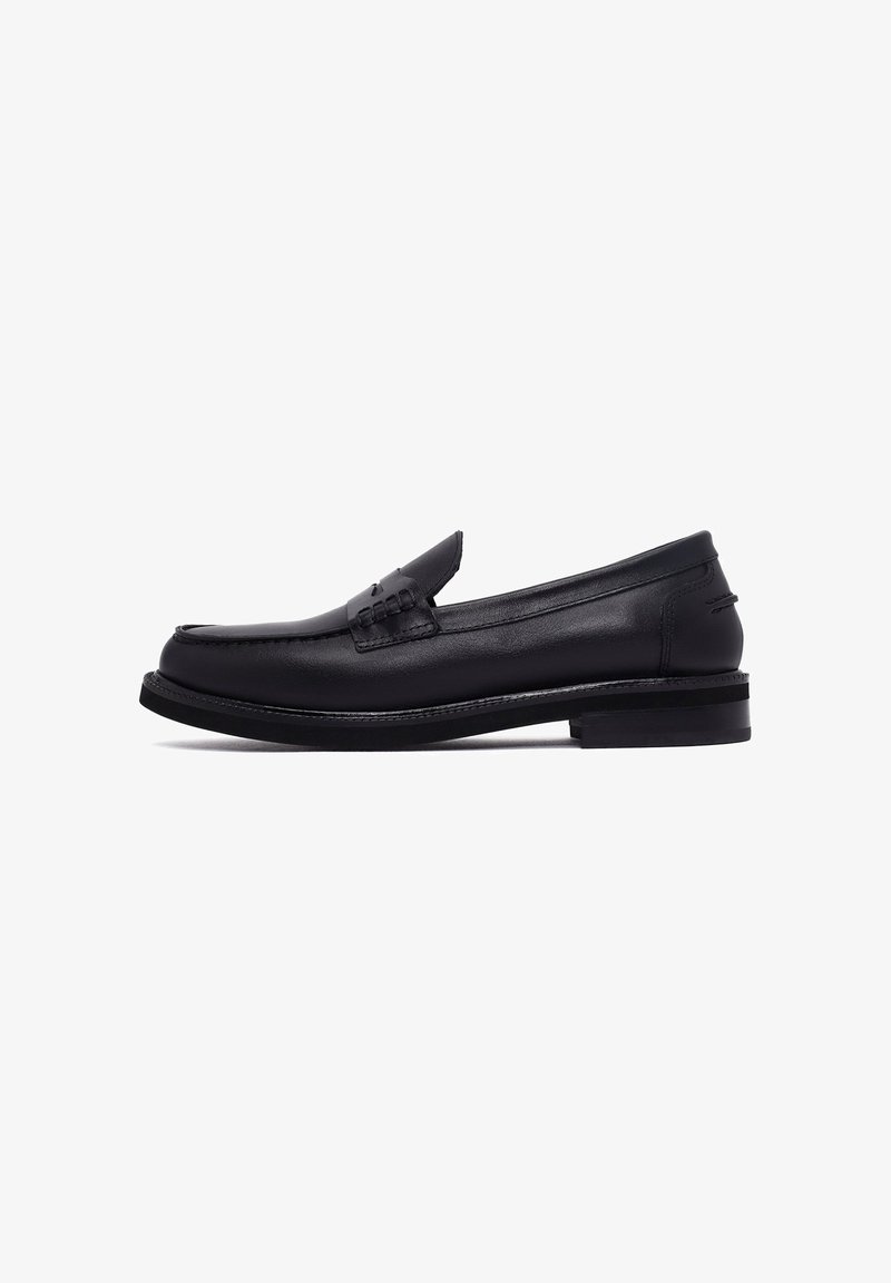 Black leather loafer with a smooth finish, raised stitched accent on the vamp, and a low stacked heel. Classic design and rounded toe.