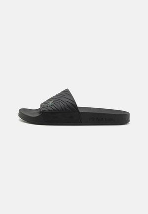 Black slide sandal with a textured upper featuring wavy patterns. Flat sole with a smooth finish and minimal branding on the side.
