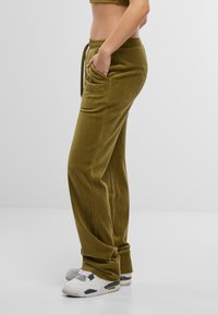 Olijfgroene velours sweatpants met een relaxed fit, voorzien van zijzakken, een elastische tailleband en een trekkoord. Gekleurd logo detail op de heup.