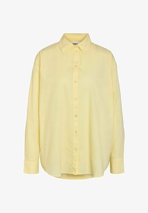 Lichtgele blouse met lange mouwen, knoopsluiting, brede kraag en afgeronde zoom, getoond tegen een witte achtergrond.