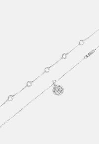 Silberne Kettenhalskette mit runden Kristalldetails und einem runden Anhänger mit filigranem Design und umliegenden Strasssteinen.