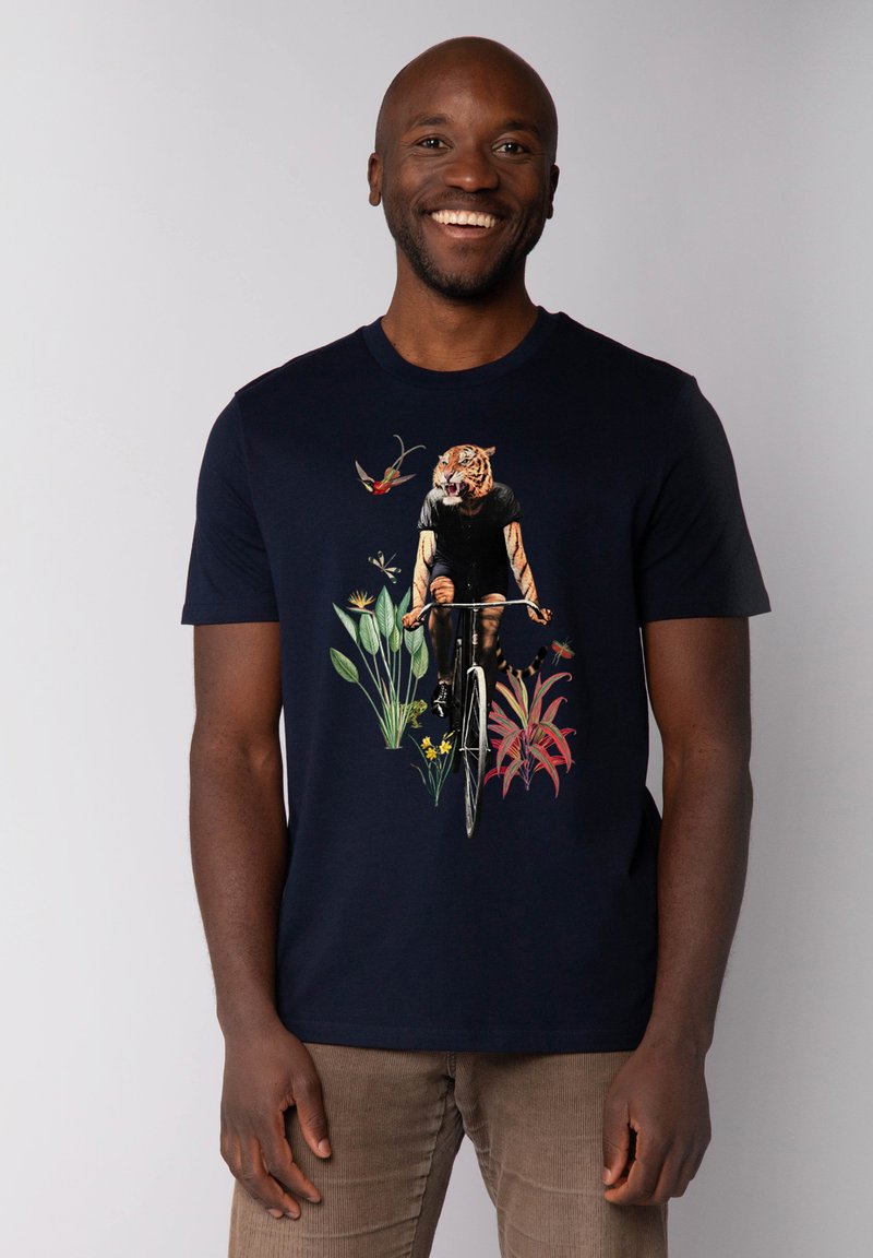 Marine t-shirt met een fietser met een tijgerkop, omringd door kleurrijke bloemillustraties. Korte mouwen en een ronde halsontwerp.