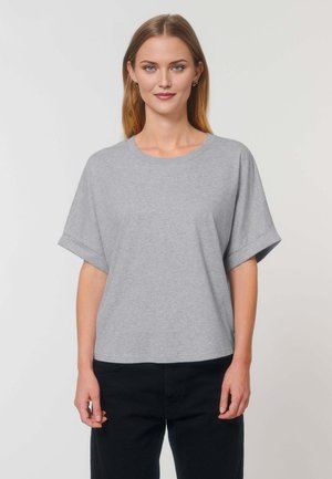 Grijze T-shirt met korte mouwen, gemaakt van zachte katoenjersey. Heeft een ronde hals en een ontspannen pasvorm. G gedragen met donkere broek.