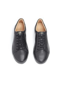 Le sneaker in pelle nera presentano una superficie liscia, punta rotonda, sei occhielli e una soletta di colore chiaro con il marchio. La suola è piatta e slanciata.
