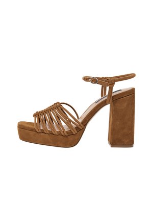 Sandalias de ante marrón con tacón grueso, punta abierta y diseño de correas entrelazadas. Incluye una correa en el tobillo con hebilla metálica.
