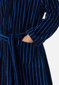 Accappatoio blu navy con strisce verticali azzurro chiaro, realizzato in tessuto morbido, dotato di cintura, maniche lunghe e tasche laterali.