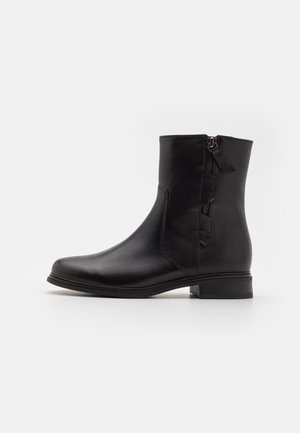 Svart lær ankelstøvel med rund tå, glidelåser på siden og minimalistisk design. Lav blokkheel og jevn tekstur gjennom hele.