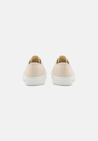 Világos rózsaszín vászon slip-on cipők texturált felülettel, fehér gumitalppal és diszkrét márkázással a sarkon.
