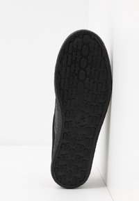 Sole di calzature nera con motivo testurizzato, forme rettangolari e esagonali, con un logo e indicazione della taglia. Progettata per la trazione.