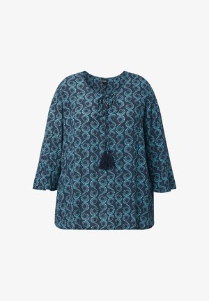 Granatowa bluzka w jasnoniebieskie kropki w kształcie kół, z rękawami do łokcia, dekoltem z wiązaniem na sznurowadła i frędzlami z przodu.