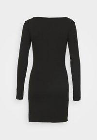 Robe noire côtelée à manches longues avec un col rond, coupe ajustée et texture lisse, s'arrêtant à la mi-cuisse. Sans motifs ni accents.