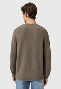 Heren oversized trui in olijfgroen, met een textuur breiwerk, ronde hals en geribde mouwen en onderrand, vanaf de achterkant gepresenteerd.