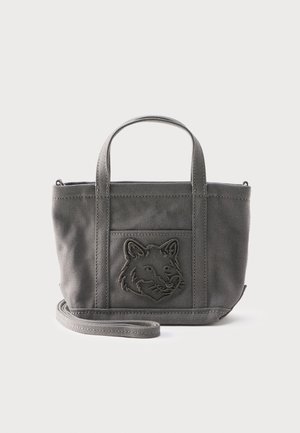 Mala siva platnena torba s dva držača, odvojivim remenom i urezanim dizajnom glave vuka na prednjem džepu.