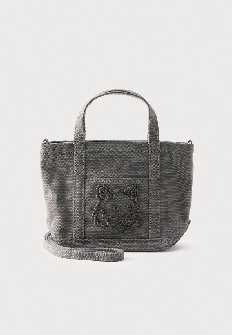 Μικρή γκρι υφασμάτινη τσάντα ώμου με δύο λαβές, αποσπώμενο λουρί και ανάγλυφο σχέδιο κεφαλής λύκου στην μπροστινή τσέπη.