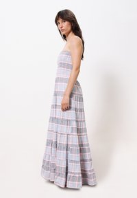 Trägerloses Maxikleid aus leichtem Stoff mit karierter Musterung in Pastellfarben. Verfügt über einen gestuften, fließenden Rock und ein tailliertes Oberteil.
