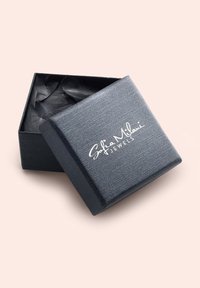 Scatola di gioielli nera con texture, con il coperchio leggermente aperto che rivela della carta velina nera all'interno. Presenta un logo del marchio in rilievo bianco sulla parte superiore.