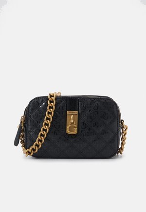 Sac bandoulière matelassé noir avec motif embossé, sangle chaîne dorée et fermoir doré avec logo "G" et marque "GUESS".