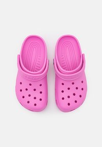 Pink clogs made of lightweight material with ventilation holes. Features a wide, contoured footbed and a back strap for a secure fit.