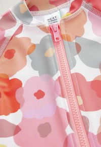 Färgglad blommig baddräkt med rosa, orange och grå mönster. Den har en central rosa dragkedja och är gjord av ett mjukt, elastiskt material.