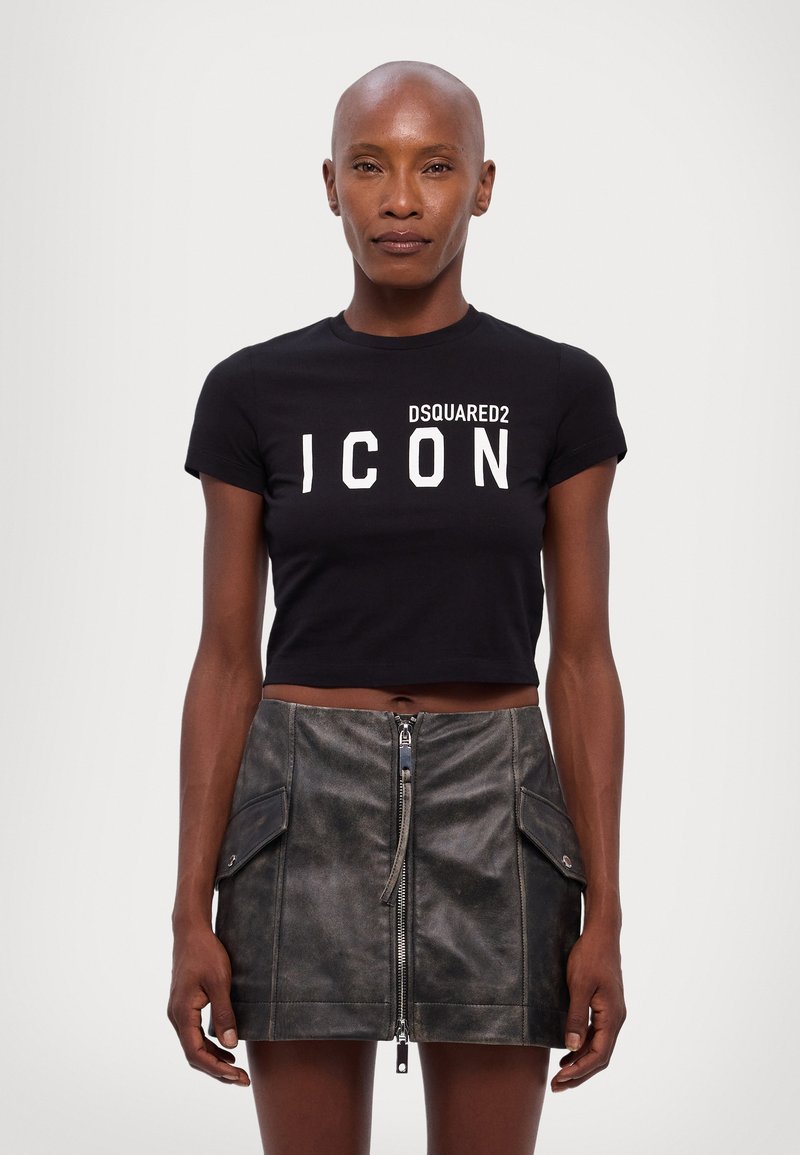 Black cropped t-shirt with white "DSQUARED2 ICON" text; paired with a dark leather mini skirt featuring a front zipper and side pockets.