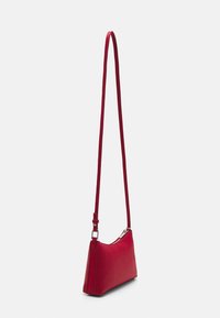 Borsa a tracolla rossa in pelle con una forma triangolare elegante, cinturino regolabile e dettagli in metallo argentato. Struttura liscia con chiusura a zip.