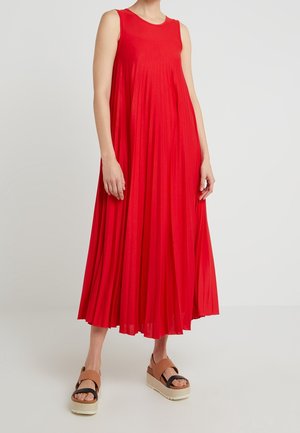 Rotes, ärmelloses Maxikleid aus leichtem Stoff, mit ausgestelltem Schnitt und Falten. Kombiniert mit hellbraunen Plateau-Sandalen.