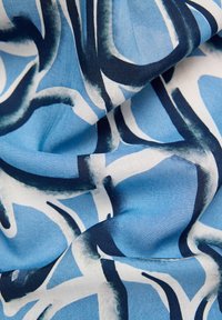 Stoff mit einem abstrakten blauen und weißen Muster sowie dunklen blauen Linien. Die Textur wirkt glatt und hat eine leichte, fließende Qualität.