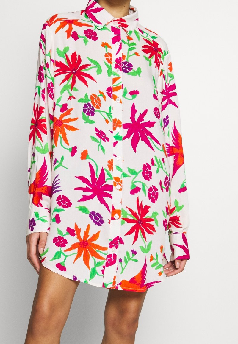 Košile s dlouhým rukávem s bílým základem a živými květinovými vzory v červené, růžové, oranžové a zelené barvě. Zapínání na knoflíky a klasický límec.