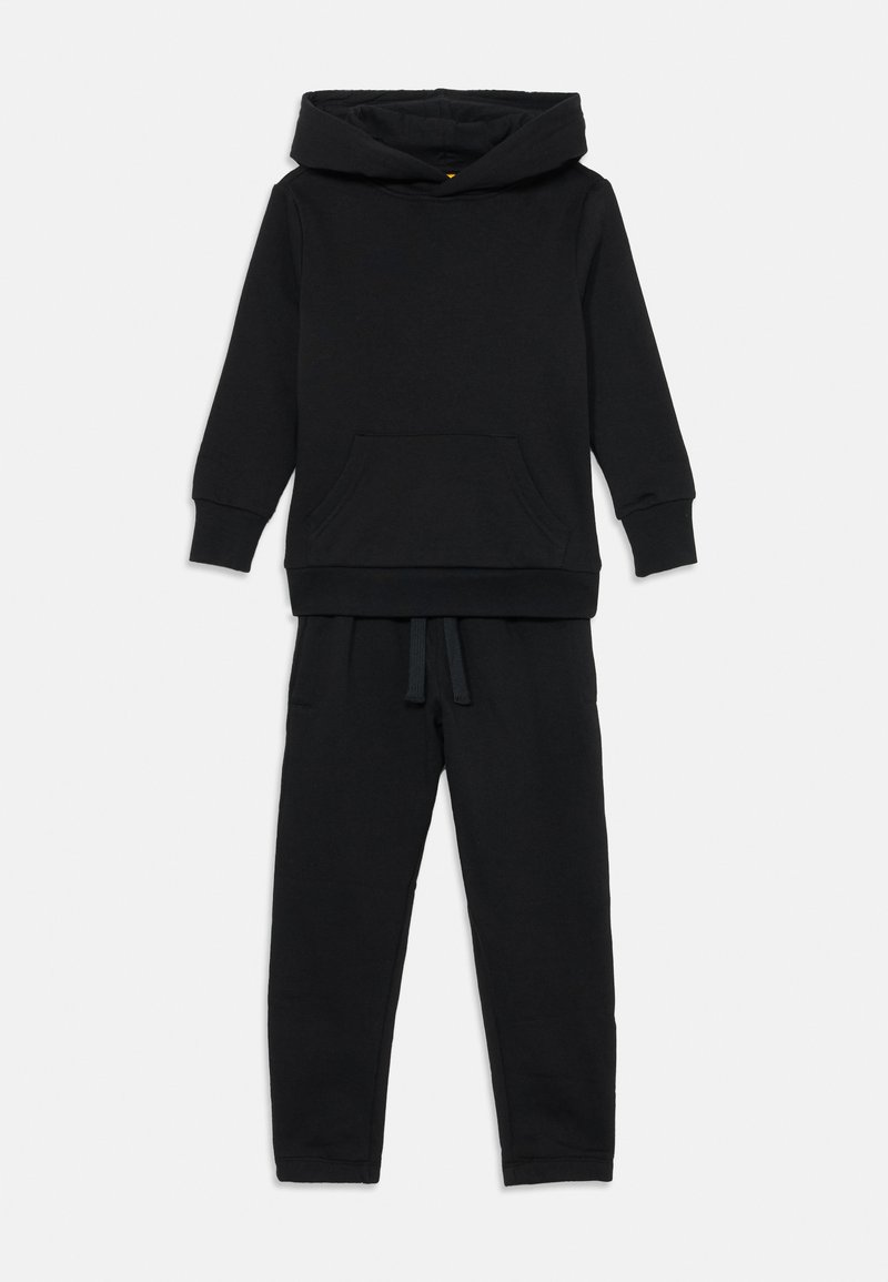 Melna kapuce ar priekšējo kabatu un melni jogger bikses ar auklu viduklī, pozicionētas uz baltā fona.