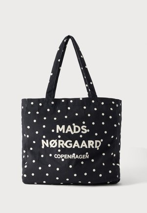 Schwarze Tote-Tasche mit weißen Punkten, vorne mit weißem Text "MADS NØRGAARD COPENHAGEN" und zwei Schulterriemen.