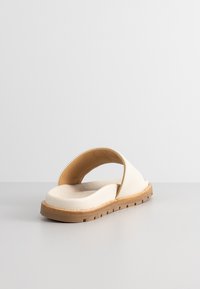 White open-back sandal with a smooth leather upper, rounded toe, beige rubber sole, and slight texture on the footbed.