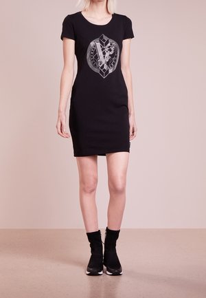 Robe noire à manches courtes avec un imprimé graphique mettant en avant des formes géométriques et un emblème central. Le matériau semble lisse et extensible.