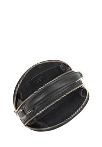 Zwarte leren ovale crossbody tas met twee open ritscompartimenten en een korte handgreep aan de bovenkant.